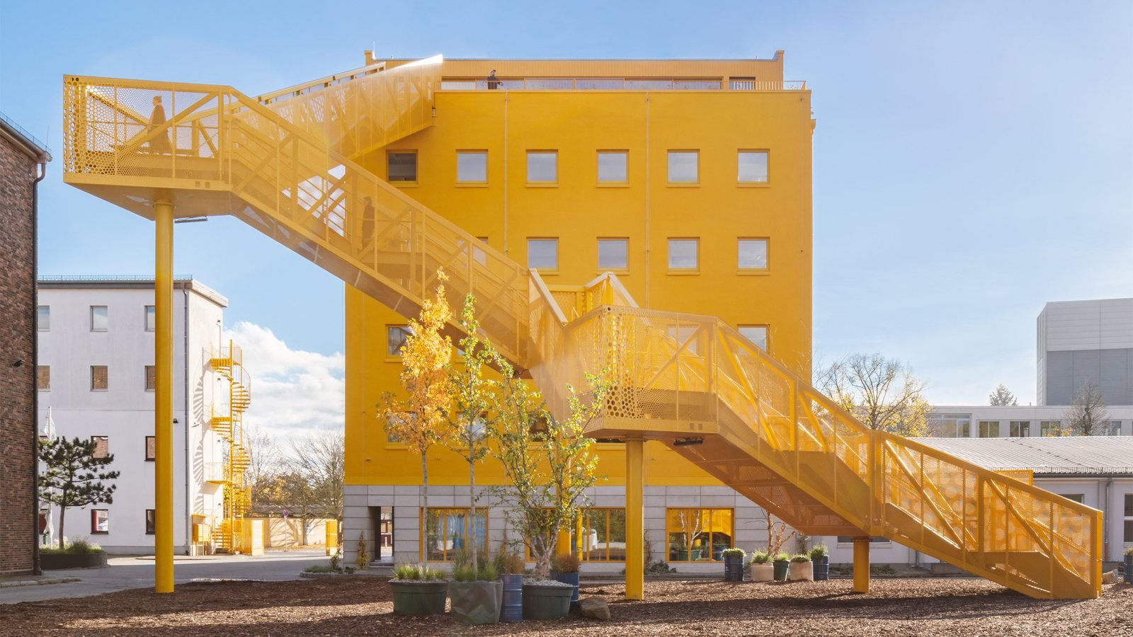 Gelbe skulpturale Außentreppe an Haus 1 der Atelier Gardens in Berlin Tempelhof, saniert von 73grad
