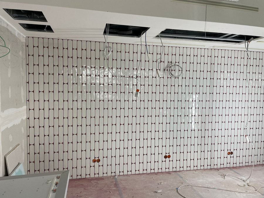 Ovale cremefarbene Wandfliesen mit dunkelroter Fuge
